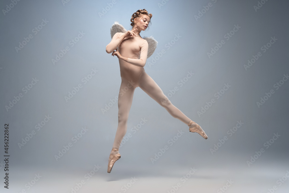 Fototapeta premium Young and graceful ballet dancer, ballerina dancing isolated on white gray studio background. Art, motion, action, flexibility, inspiration concept.
