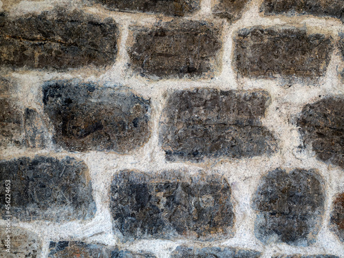 Ancient wall masonry from chipped granite blocks. Wall stone pattern.