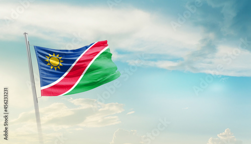 Namibia national flag cloth fabric waving on the sky - Image