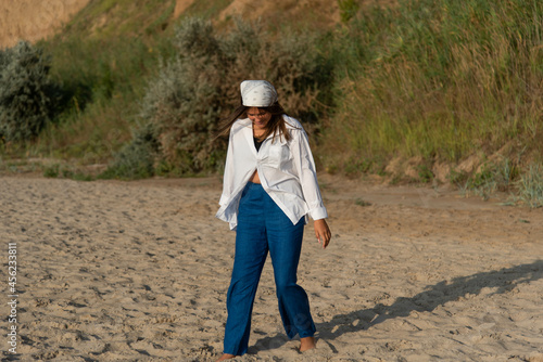 Сute teenage girl or woman wearing blue pants, white shirt, white bandana on the beach nature landscape fresh air beach. Natural beauty. lifestyle, real people, funny, dance.