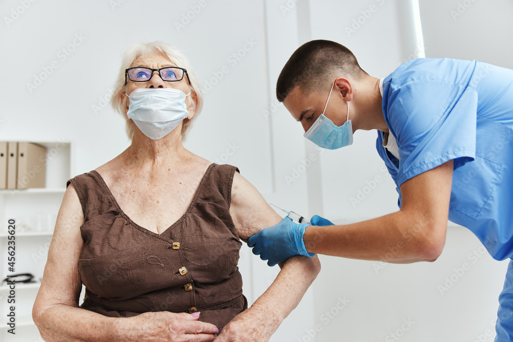 Obraz premium male doctor giving an injection vaccine passport in medical masks