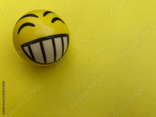 Pelota happy face amarillo sobre fondo amarillo