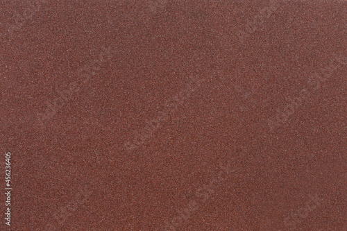 Red-brown sandpaper texture. Rough sandpaper background. Copy space.