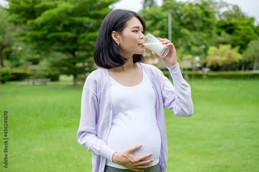 Pregnant mother sits drinking milk in a glass for good health. Pregnant mother sits drinking milk in a glass for good health.
