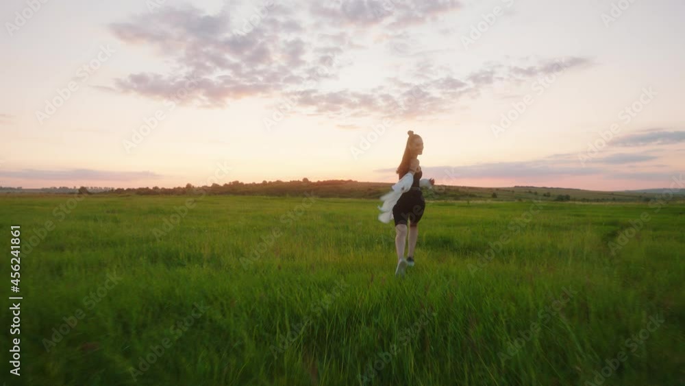 Running fast lady with sportswear through the field of grass she feels very freedom at sunset amazing video capturing Running fast lady with sportswear through the field of grass she feels very freedom at sunset amazing video capturing