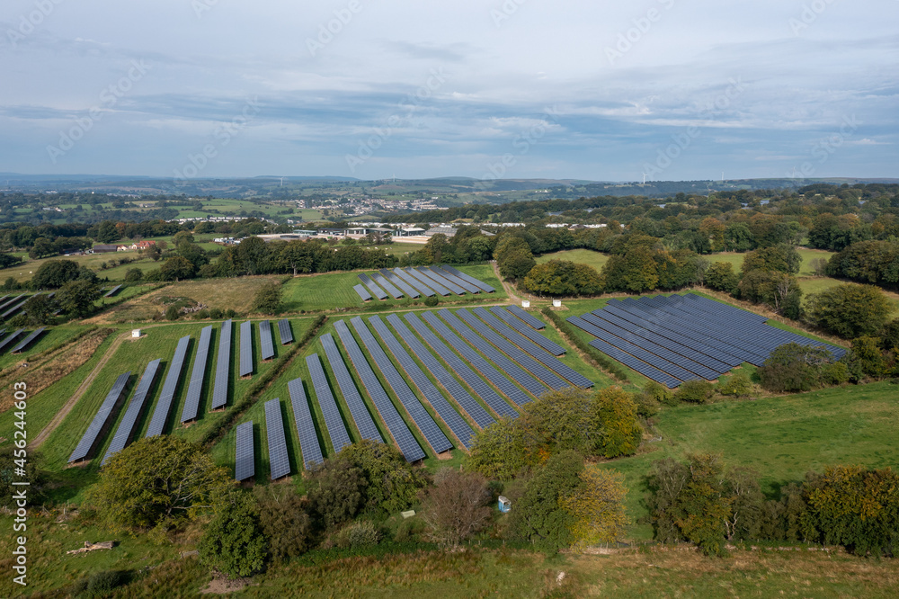 Fototapeta premium Aerial view of solar power plant on green field. Electric panels for producing clean ecologic energy.