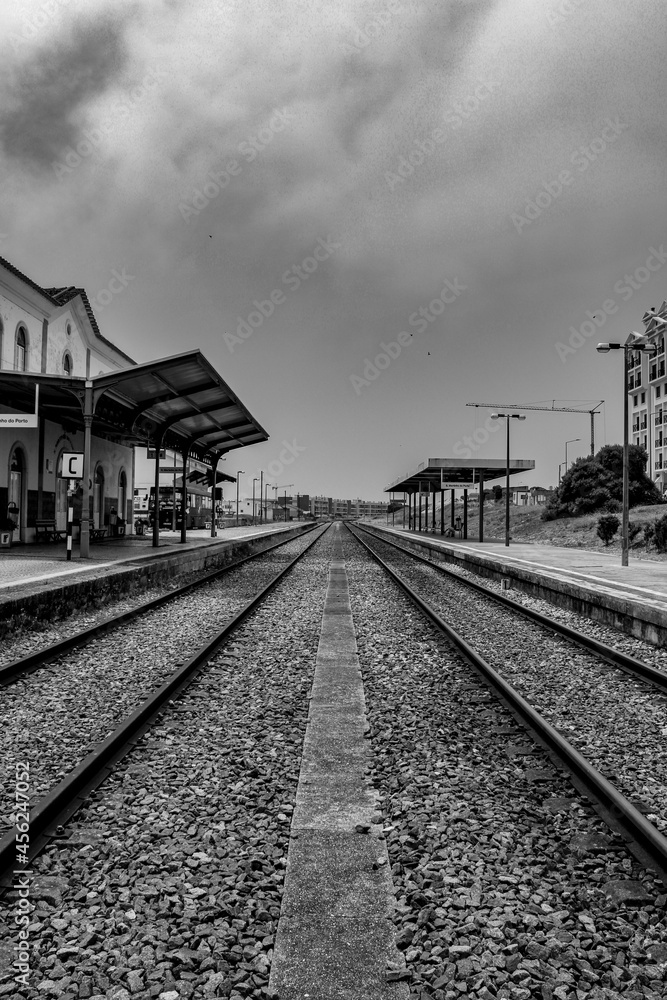 View of an old train line in São Martinho do Porto, Portugal. A nostalgic view of a train station in shades of white and black.