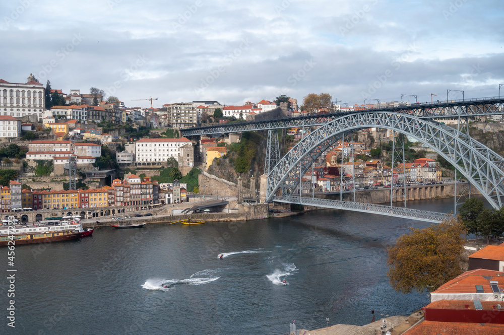 Porto, Portugal, October 31,2020. View on bridge, colorful old houses on hill in old part of city and embankment of Douro river in rainy day