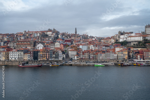 Porto, Portugal, October 31,2020. View on colorful old houses on hill in old part of city and embankment of Douro river in rainy day