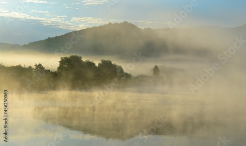 Misty lake in the hills at summer dawn. Arló, Hungary.