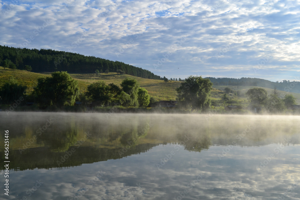 Misty lake in the hills at summer dawn. Arló, Hungary.