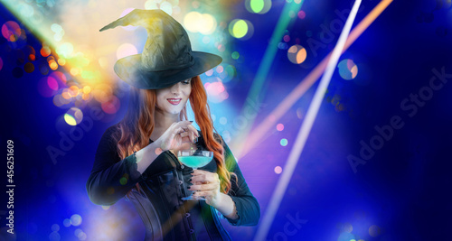 Halloween Witch Woman with long red hair and holiday make-up wearing dark tapered witch's hat