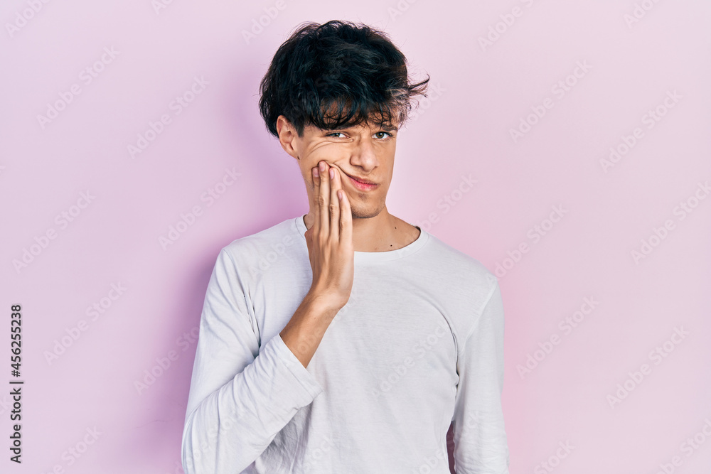 Handsome hipster young man wearing casual white shirt touching mouth with hand with painful expression because of toothache or dental illness on teeth. dentist Handsome hipster young man wearing casual white shirt touching mouth with hand with painful expression because of toothache or dental illness on teeth. dentist