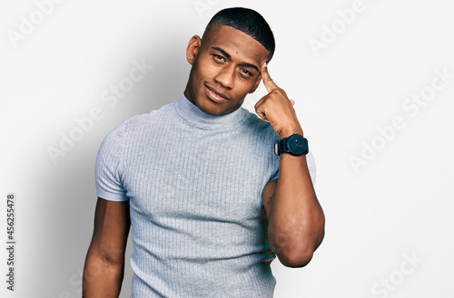 Young black man wearing casual t shirt smiling pointing to head with one finger, great idea or thought, good memory