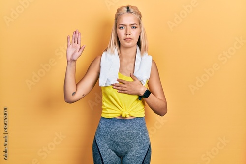 Beautiful blonde sports woman wearing workout outfit swearing with hand on chest and open palm  making a loyalty promise oath