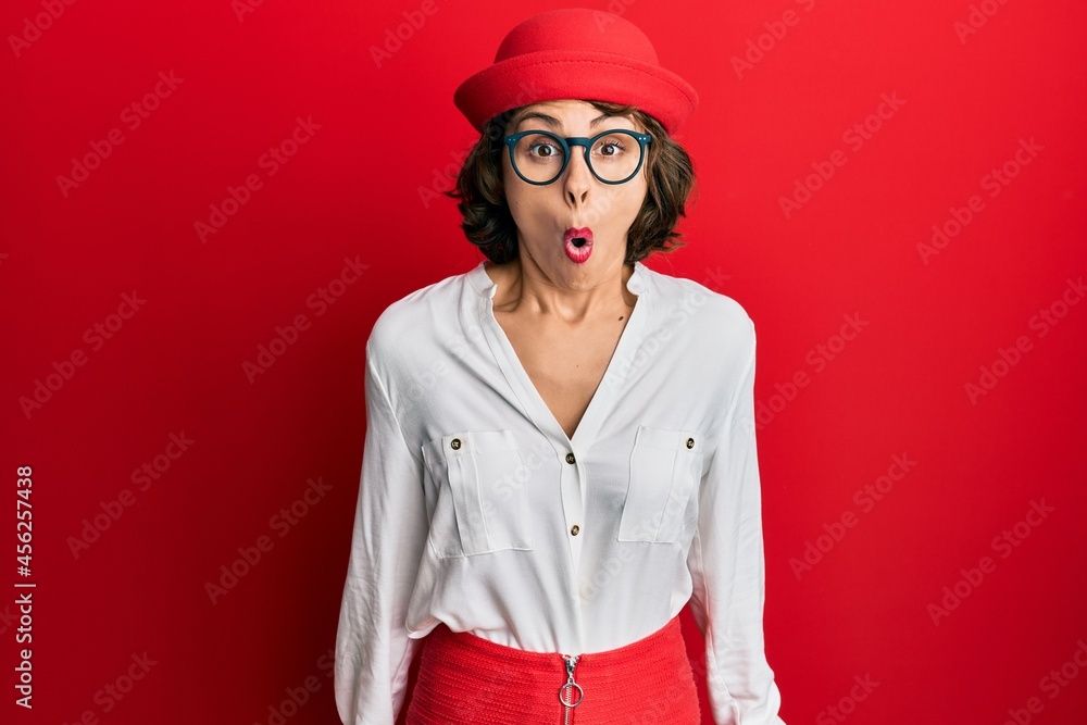 Young brunette woman wearing stewardess style and glasses scared and amazed with open mouth for surprise, disbelief face Young brunette woman wearing stewardess style and glasses scared and amazed with open mouth for surprise, disbelief face