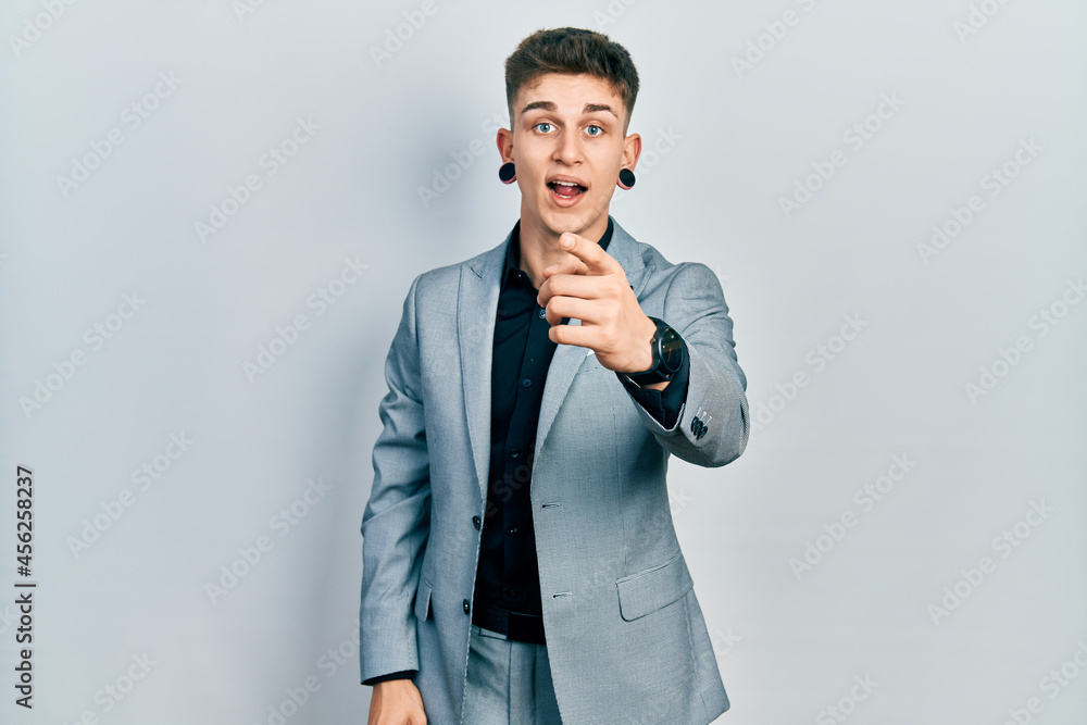 Young caucasian boy with ears dilation wearing business jacket pointing displeased and frustrated to the camera, angry and furious with you Young caucasian boy with ears dilation wearing business jacket pointing displeased and frustrated to the camera, angry and furious with you