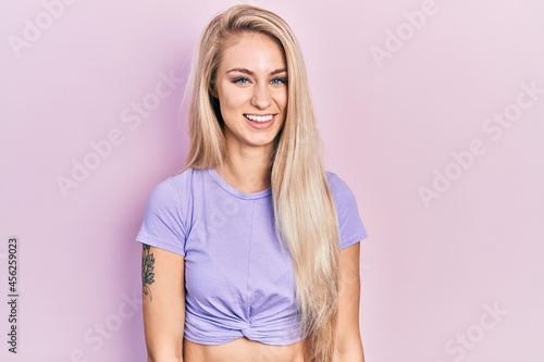Young beautiful caucasian woman wearing casual t shirt looking positive and happy standing and smiling with a confident smile showing teeth