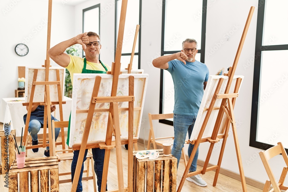 Group of middle age people artist at art studio with angry face, negative sign showing dislike with thumbs down, rejection concept