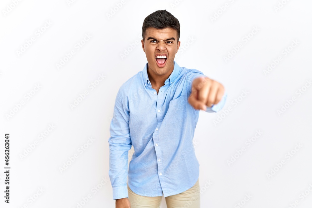 Young hispanic man wearing business shirt standing over isolated background pointing displeased and frustrated to the camera, angry and furious with you Young hispanic man wearing business shirt standing over isolated background pointing displeased and frustrated to the camera, angry and furious with you