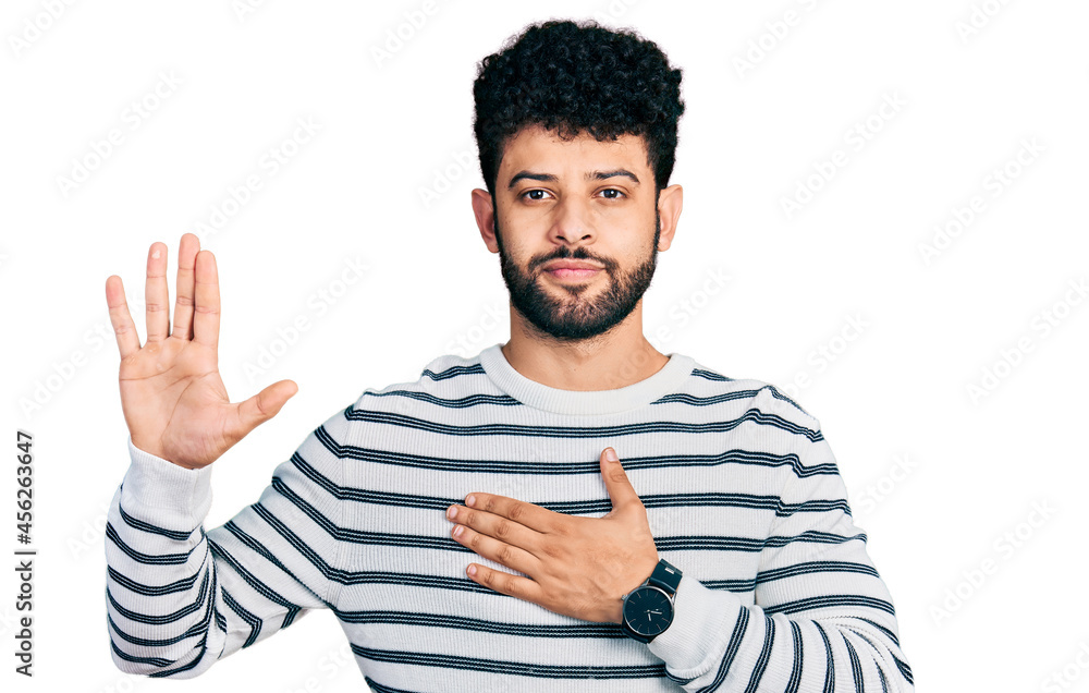 Young arab man with beard wearing casual striped sweater swearing with hand on chest and open palm, making a loyalty promise oath Young arab man with beard wearing casual striped sweater swearing with hand on chest and open palm, making a loyalty promise oath