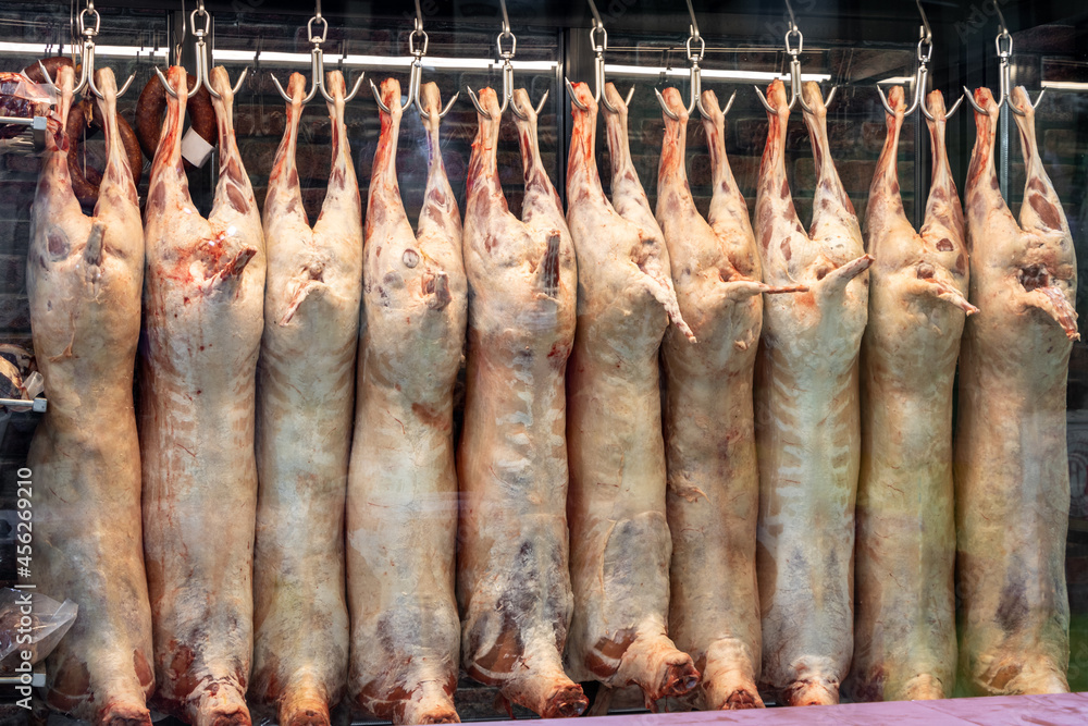Lamb carcass meats hung on hooks in the slaughterhouse, butcher shop