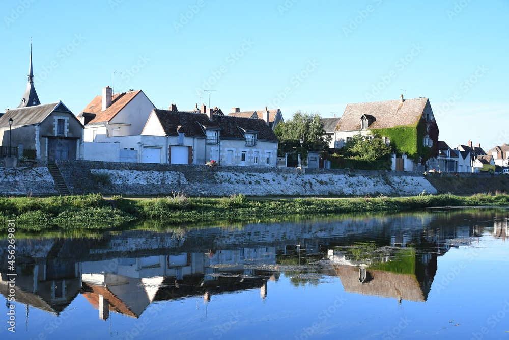 Reflet des maisons de village sur la rivière au lever du soleil