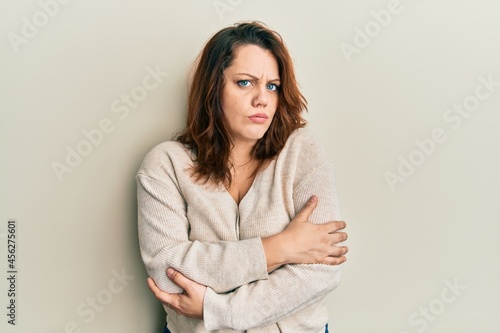 Young caucasian woman wearing casual clothes shaking and freezing for winter cold with sad and shock expression on face