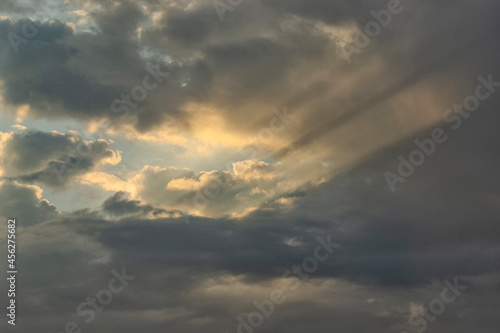 Sunbeams piercing the clouds at dawn. © zoya54