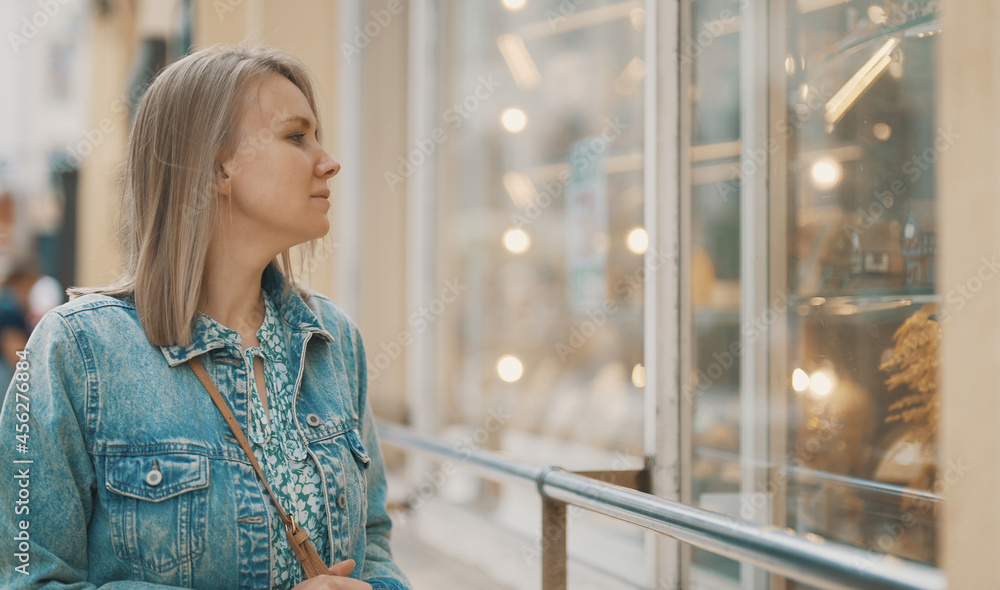 Female tourist looking at the shop window with souvenirs. Female tourist looking at the shop window with souvenirs.