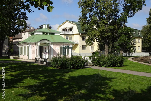 Light pink and yellow buildings in green park Kadriorg on a summer day with blue sky. Tallinnm Estonia, Europe. August 2021