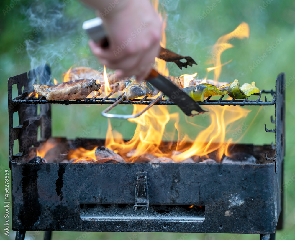 meat is fried on a flaming grill in field conditions