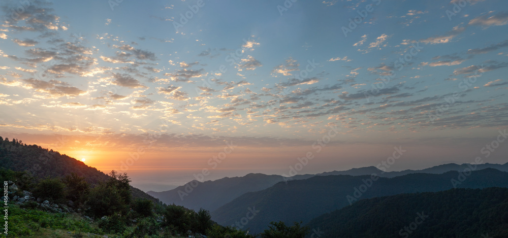 silhouette view from top of mountains at sunrise with cloudy sky in gilan province, iran.