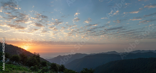 silhouette view from top of mountains at sunrise with cloudy sky in gilan province, iran. © AAref