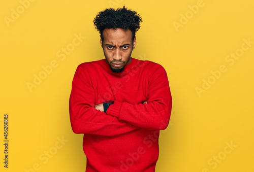 Young african american man with beard wearing casual winter sweater skeptic and nervous, disapproving expression on face with crossed arms. negative person.