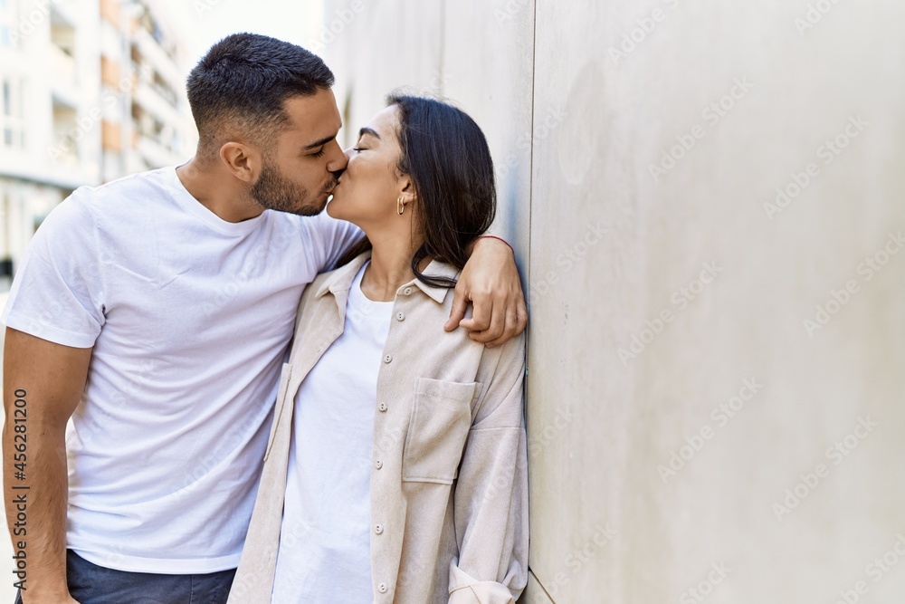 Young latin couple kissing and hugging standing at the city. Young latin couple kissing and hugging standing at the city.