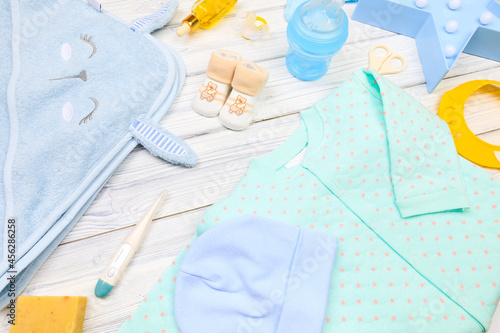 baby clothes and attributes on a white wooden background. View from above - Image