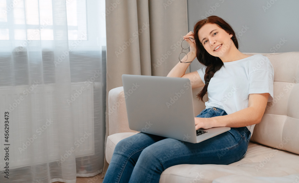 Happy employee with glasses with a satisfied expression works in modern gadgets at home. Happy employee with glasses with a satisfied expression works in modern gadgets at home.