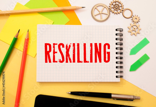 word Reskilling on white paper. Reskilling and upskilling development concept. photo
