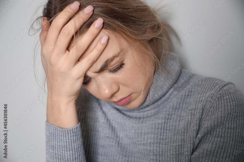 Depressed young woman on grey background Depressed young woman on grey background