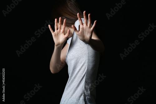 Scared young woman on dark ...