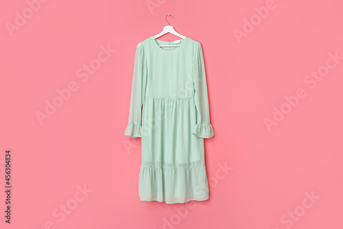 Photography Hanger with stylish female dress on color background