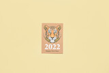 Beautiful greeting card with tiger for year 2022 on color background