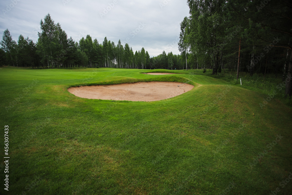 Golf course in the middle of the forest glade. 