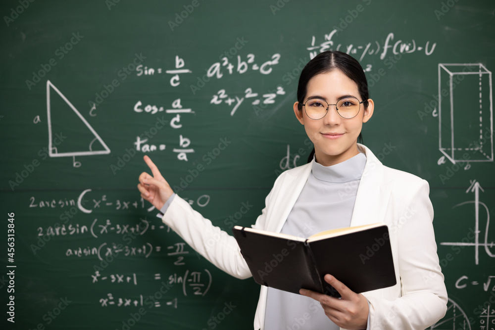 Young asian teacher woman teaching holding book and video conference with student looking camera. Female teacher training the mathematics in classroom blackboard from online course. Young asian teacher woman teaching holding book and video conference with student looking camera. Female teacher training the mathematics in classroom blackboard from online course.