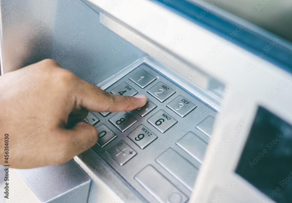 Close up male hand using atm machine withdrawal money. Man put the pin code into bank machine to take the money. Close up male hand using atm machine withdrawal money. Man put the pin code into bank machine to take the money.