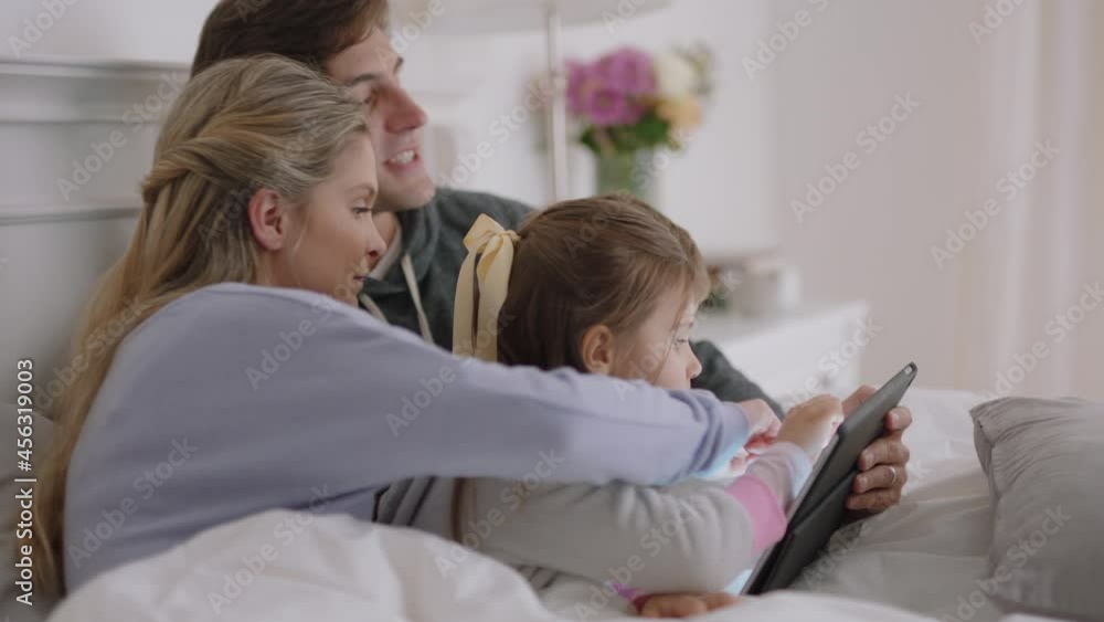 happy family using tablet computer in bed mother and father with children watching entertainment playing game on touchscreen device learning having fun together on weekend morning 4k footage happy family using tablet computer in bed mother and father with children watching entertainment playing game on touchscreen device learning having fun together on weekend morning 4k footage