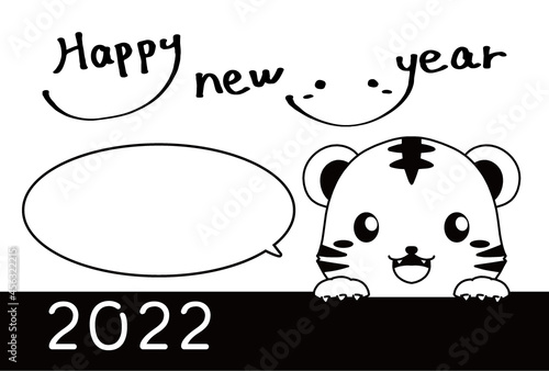 モノクロのひょっこり顔を出すトラとHappy New Yearの文字と吹き出しの2022年の年賀状