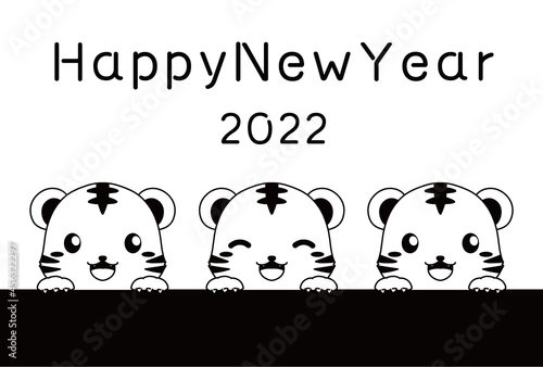 モノクロのひょっこり顔を出すトラとHappy New Yearの文字の2022年の年賀状