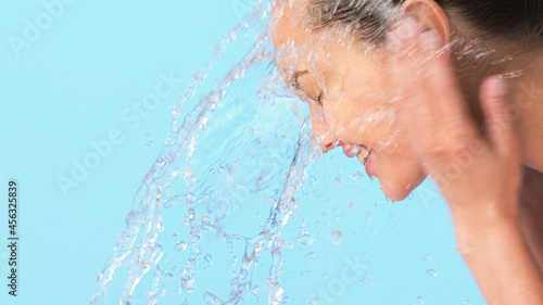 Woman washing her clean face with water. Closeup face of an Young girl washing face with water.